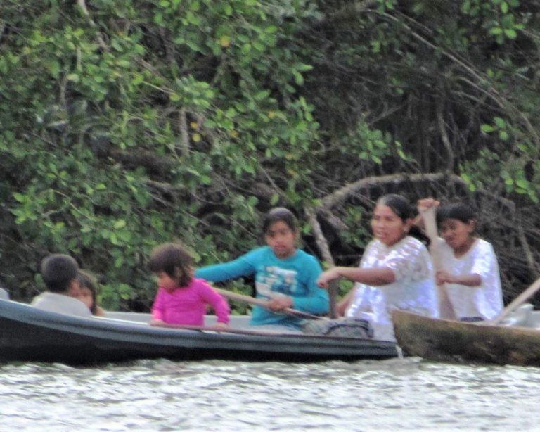 women in dug out canoes